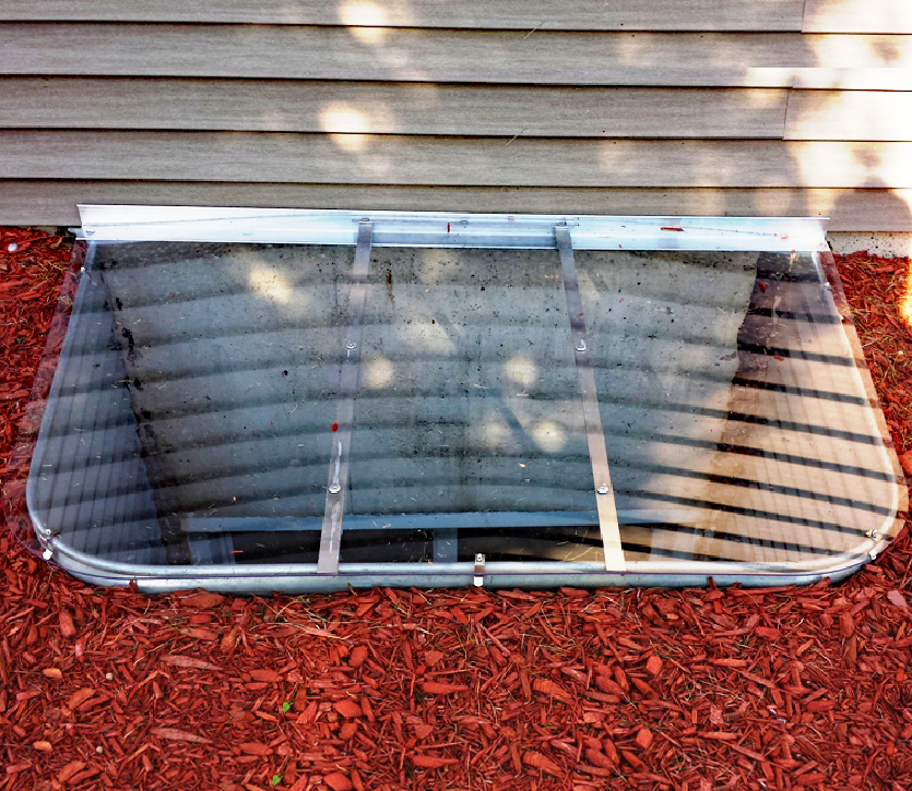 Low-profile sloped window well cover for egress metal well. Size: 56" x 36"