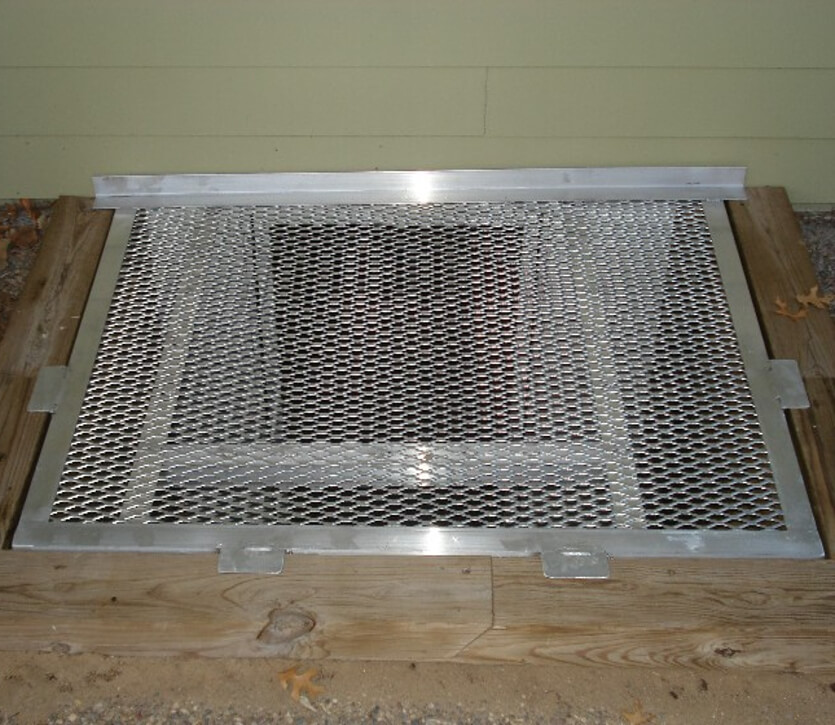 Egress aluminum grate with front tab and escape hatch.
