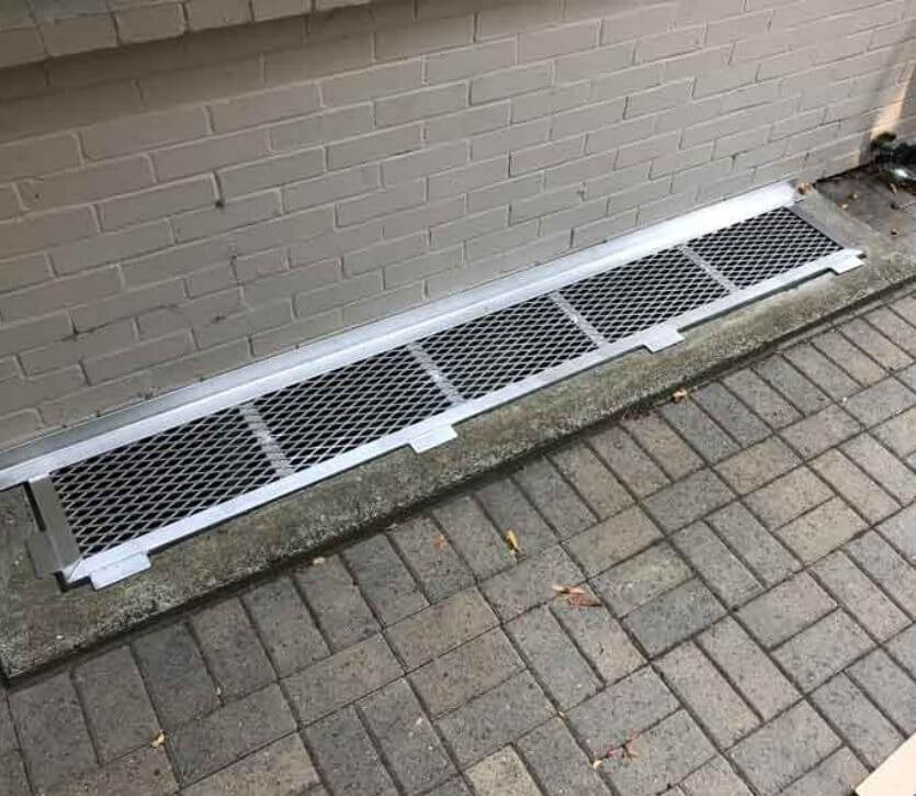84" x 13" Durable aluminum grate, custom designed to fit the long and narrow concrete well