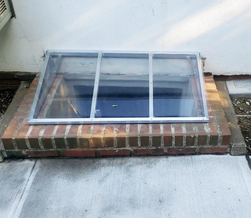 Small super-slant cover on brick window well. Size: 48" x 26"