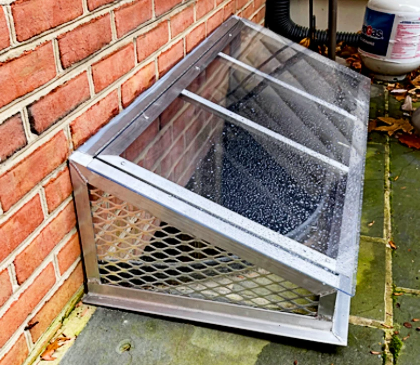 Tall super-slant window well cover with mesh sides and a front mesh panel.