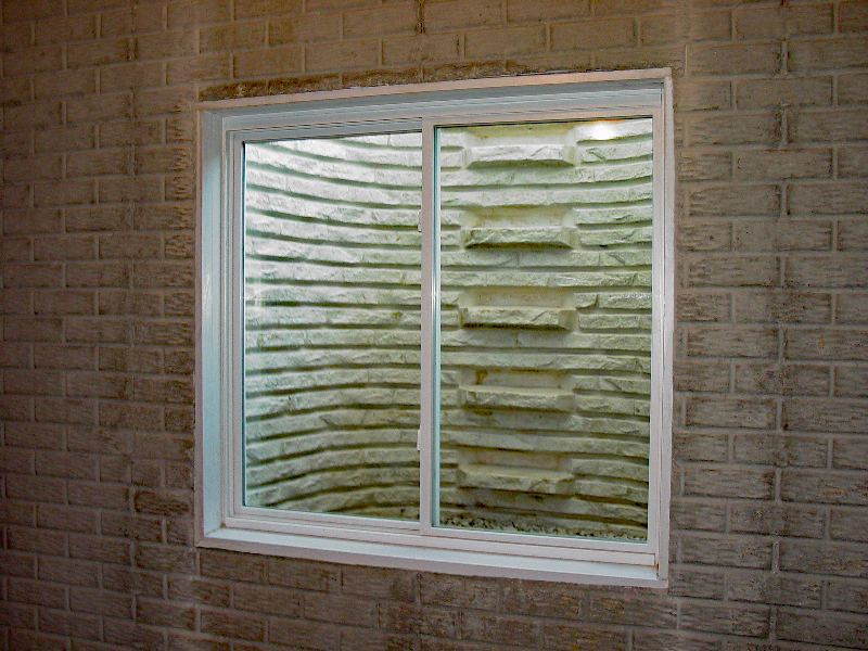 Sliding egress window with white faux stone window well egress kit