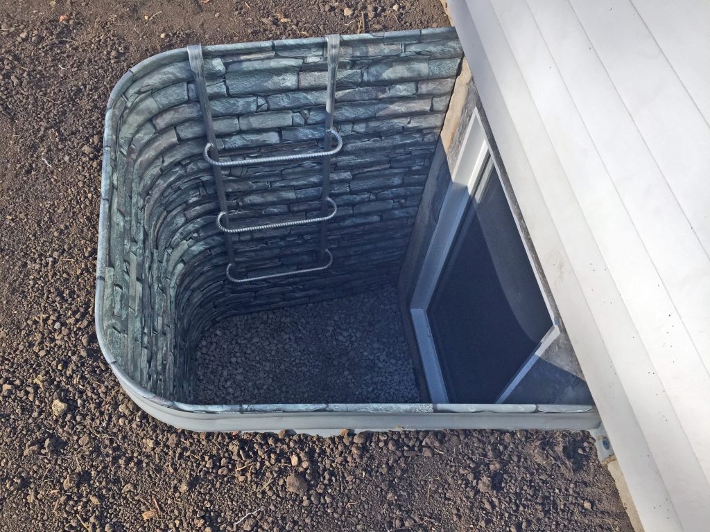 Decorative stone egress well, gray color, installed